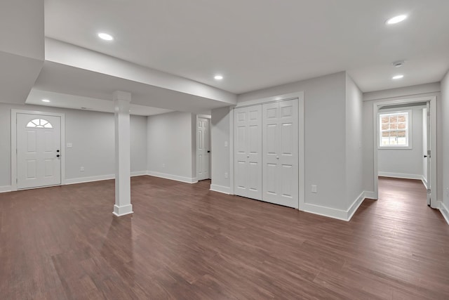 basement featuring dark wood-type flooring, baseboards, and recessed lighting