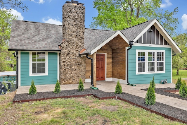 view of front of property with a shingled roof and a chimney