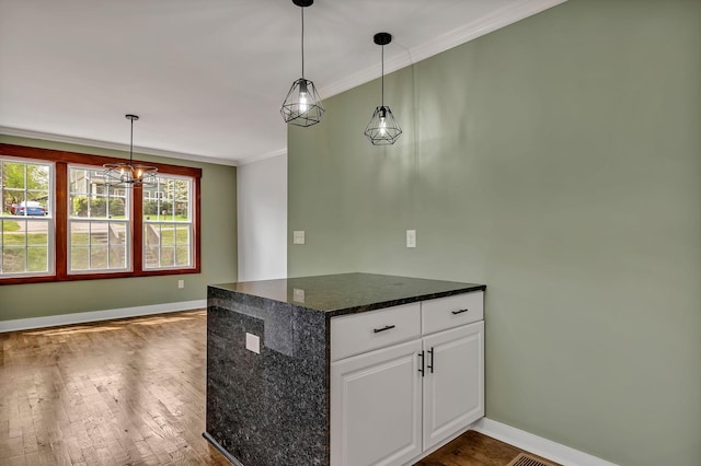 kitchen featuring hanging light fixtures, baseboards, ornamental molding, dark wood-style floors, and white cabinetry