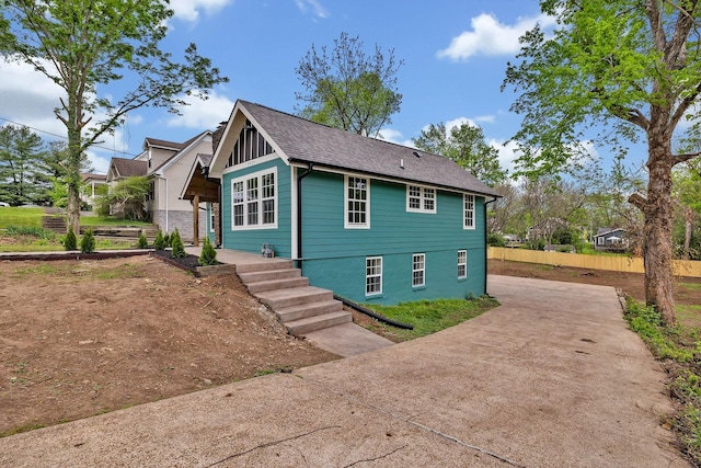 view of front of property with concrete driveway and fence