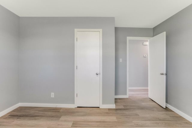 unfurnished room featuring light wood-style flooring and baseboards