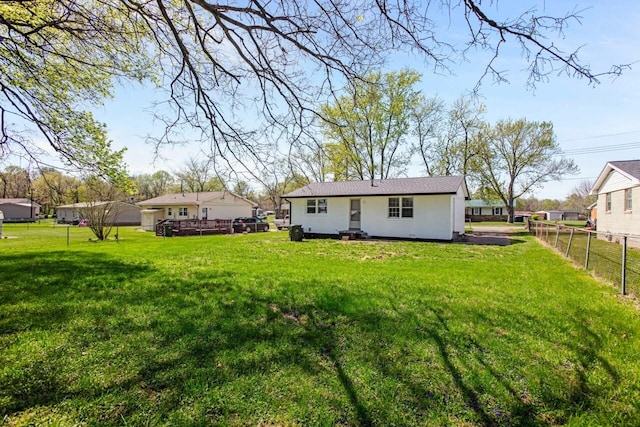 rear view of property with a yard, stucco siding, and fence
