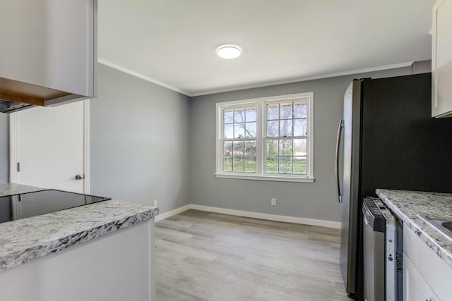 kitchen featuring light wood-type flooring, white cabinetry, ornamental molding, and stainless steel appliances