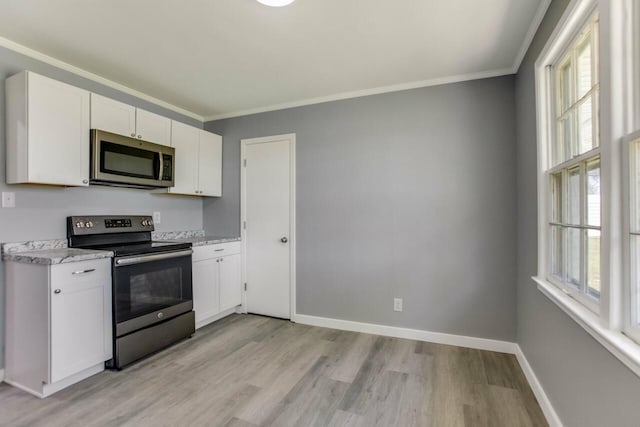 kitchen with light wood finished floors, white cabinetry, crown molding, and appliances with stainless steel finishes