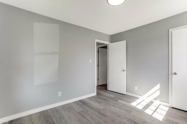 unfurnished bedroom with baseboards and wood finished floors