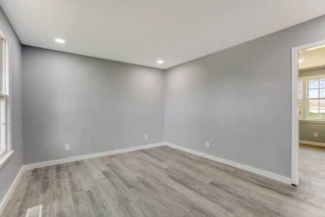 unfurnished room with recessed lighting, visible vents, baseboards, and wood finished floors