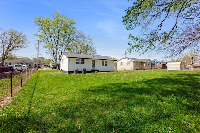 rear view of house with a yard and fence