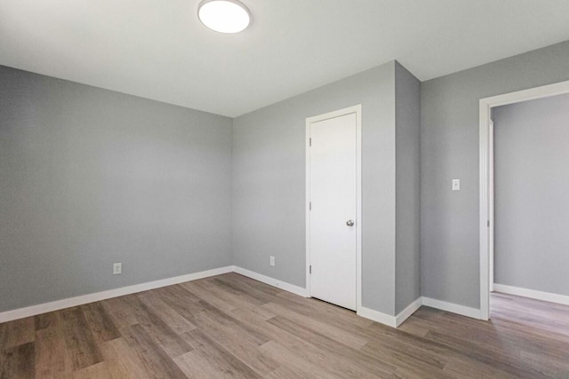 empty room with baseboards and wood finished floors