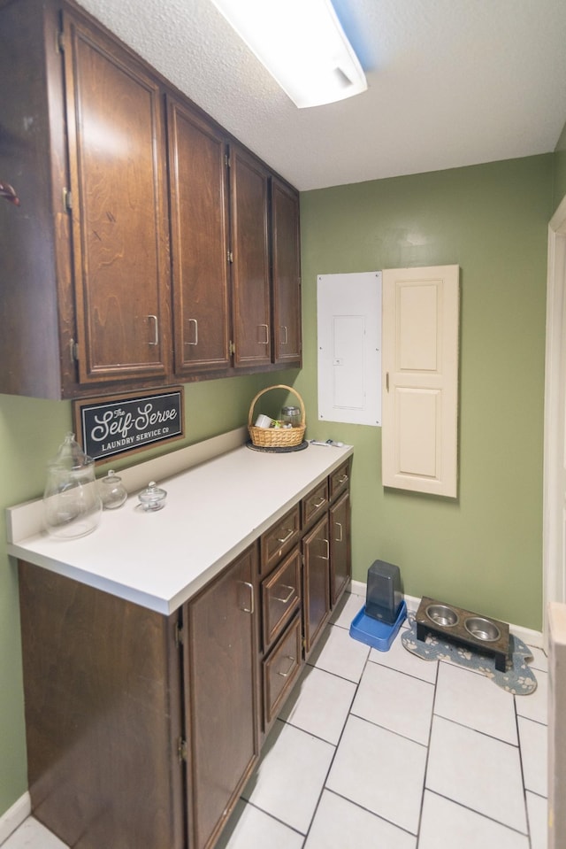 laundry room featuring light tile patterned floors and baseboards