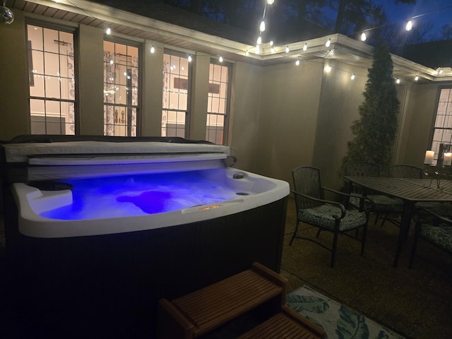 patio at twilight featuring a hot tub