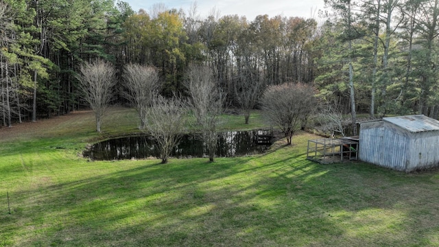 view of yard featuring a view of trees and an outbuilding