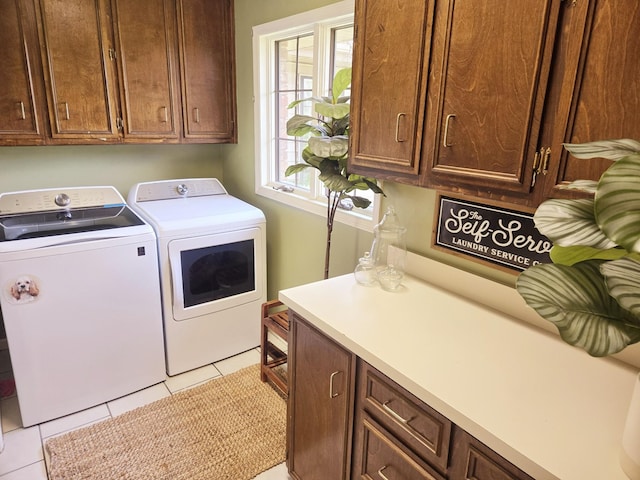 clothes washing area featuring cabinet space, washing machine and clothes dryer, and light tile patterned flooring