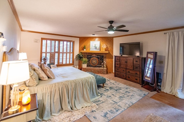 bedroom with crown molding, wooden walls, a fireplace, and a ceiling fan