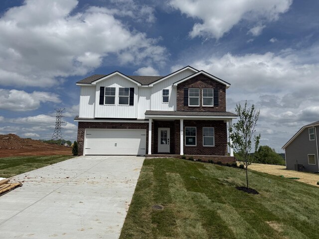 203 Boson Ct, Columbia, TN 38401 - traditional home with central AC unit, driveway, brick siding, a front yard, and a garage