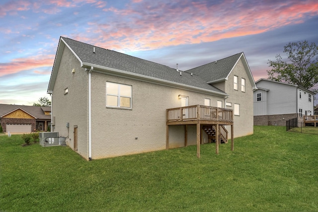 rear view of property featuring a yard, central AC unit, a wooden deck, and stairs