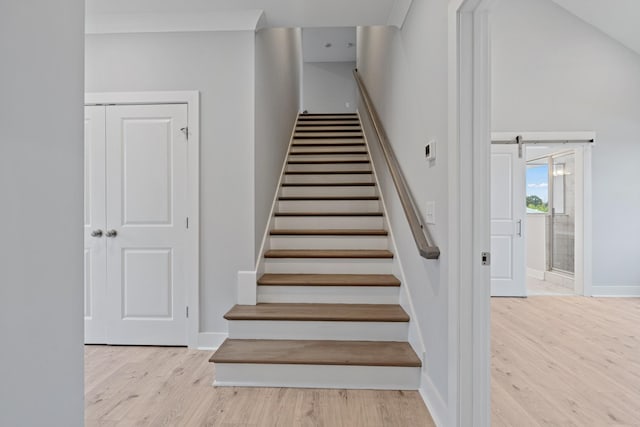 stairs with wood finished floors and baseboards