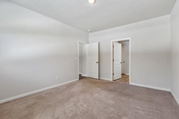 unfurnished bedroom featuring carpet flooring and baseboards