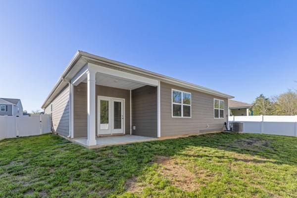 back of property with central AC, a fenced backyard, a patio area, and a lawn