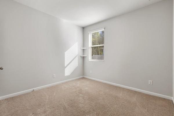 carpeted spare room with baseboards