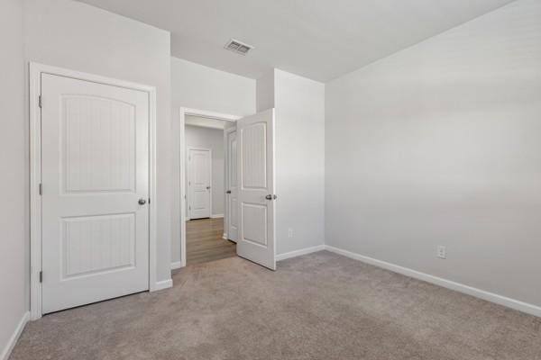 unfurnished bedroom featuring baseboards, visible vents, and carpet floors