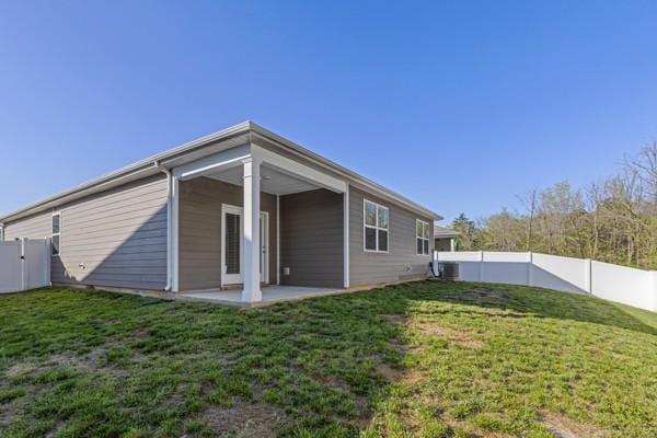back of house featuring a patio area, a fenced backyard, and a lawn