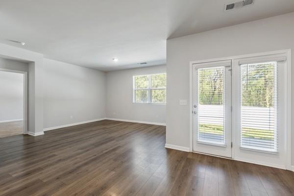 interior space featuring visible vents, baseboards, and dark wood-style floors