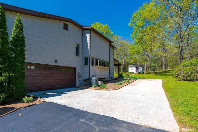 view of home's exterior with an attached garage, a yard, aphalt driveway, and central air condition unit