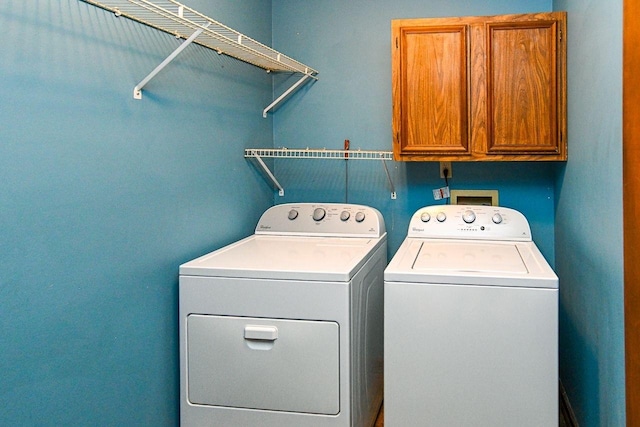 washroom featuring washer and dryer and cabinet space