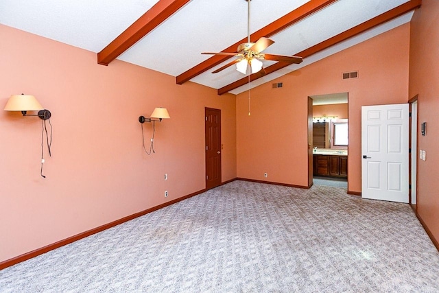 spare room featuring baseboards, a ceiling fan, visible vents, beamed ceiling, and light colored carpet