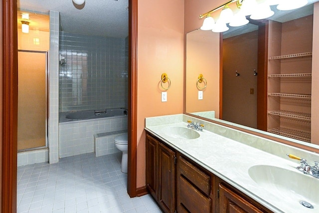 full bathroom featuring toilet, tile patterned floors, tiled shower, and a sink