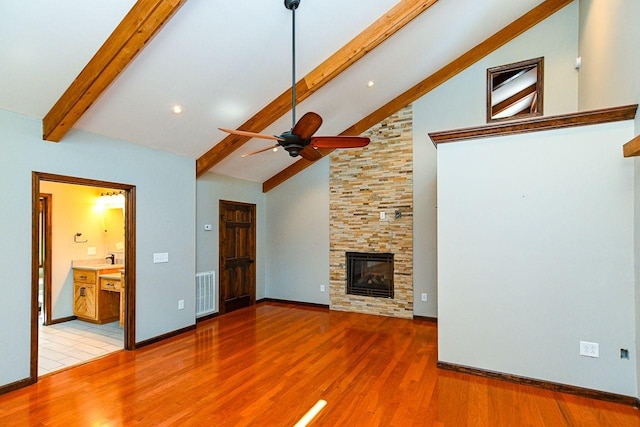 unfurnished living room with ceiling fan, high vaulted ceiling, visible vents, wood finished floors, and beam ceiling