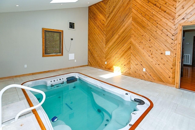 view of swimming pool with an indoor hot tub and a skylight