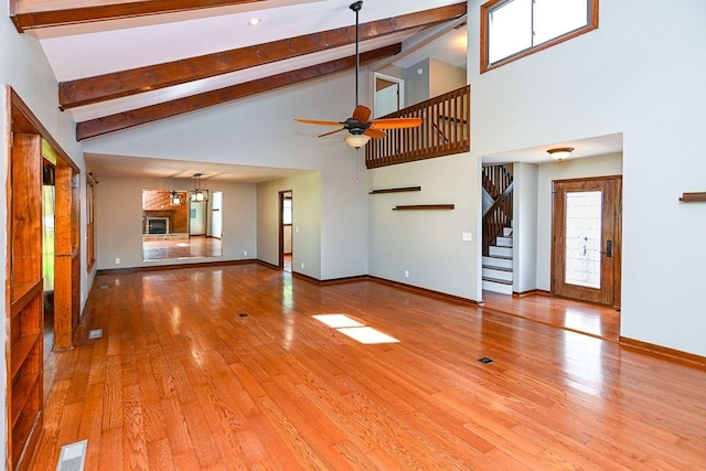 unfurnished living room with visible vents, ceiling fan, stairway, and beam ceiling