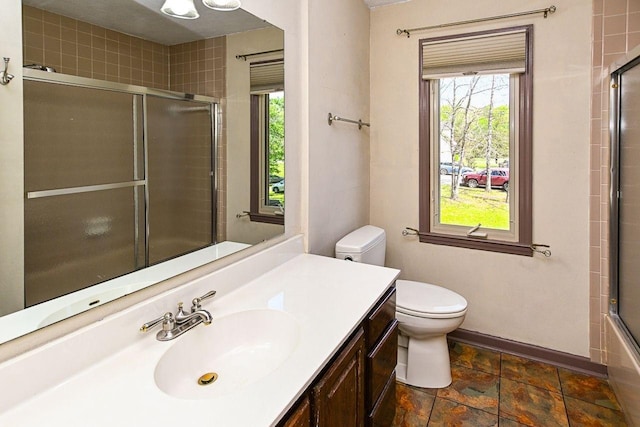 full bath with toilet, vanity, and baseboards