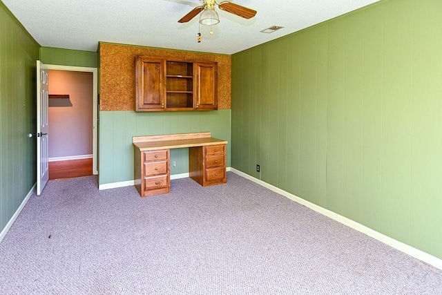 interior space featuring carpet flooring, visible vents, baseboards, and a ceiling fan