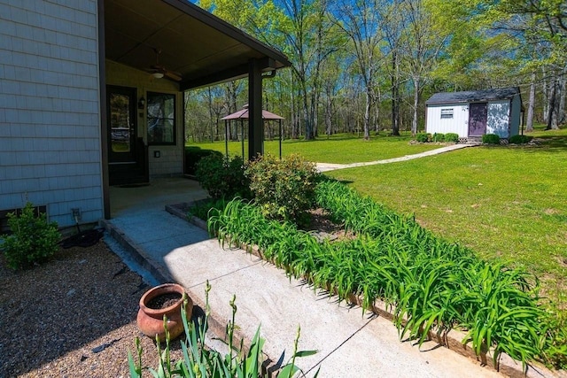view of yard with an outbuilding, a shed, and a ceiling fan