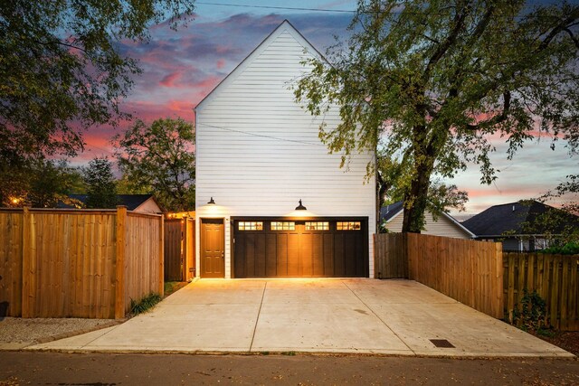 4008 Nevada Ave, Nashville, TN 37209 - property exterior at dusk with driveway, fence, and an attached garage