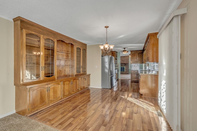 unfurnished dining area featuring a chandelier, light wood finished floors, baseboards, and ornamental molding