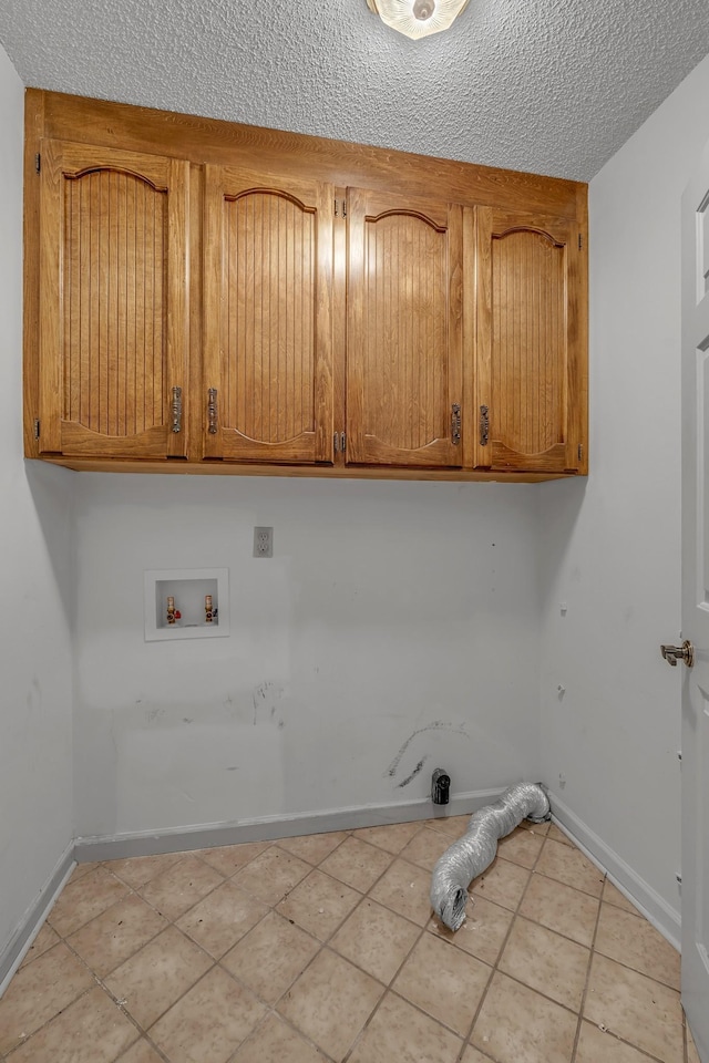 clothes washing area with light tile patterned floors, baseboards, hookup for a washing machine, and cabinet space