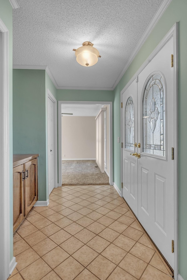 foyer entrance featuring crown molding, light tile patterned floors, baseboards, and a textured ceiling