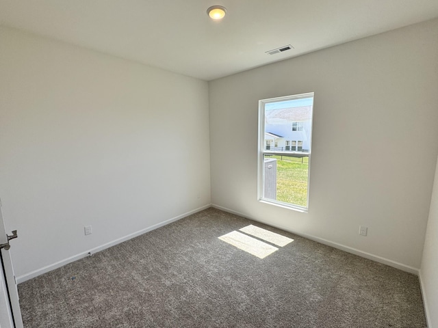 spare room with baseboards, carpet, and visible vents