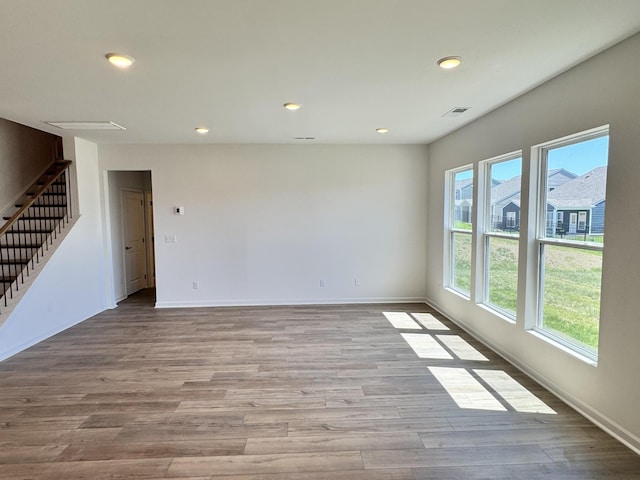 unfurnished living room featuring baseboards, recessed lighting, stairs, visible vents, and wood finished floors