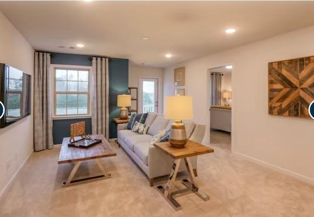 living area featuring light carpet, recessed lighting, baseboards, and a wealth of natural light