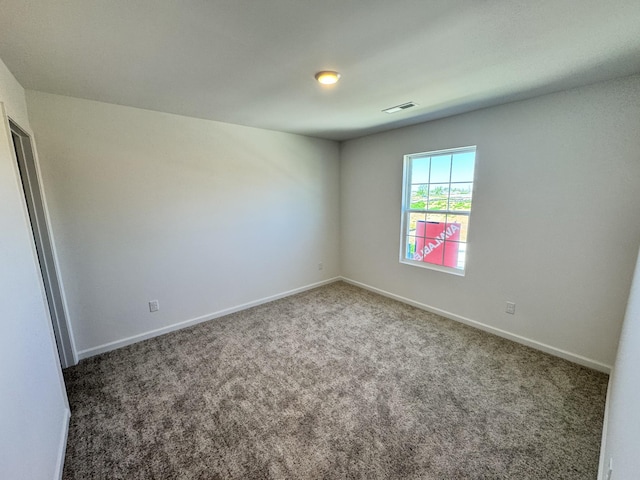 empty room featuring visible vents, baseboards, and carpet flooring