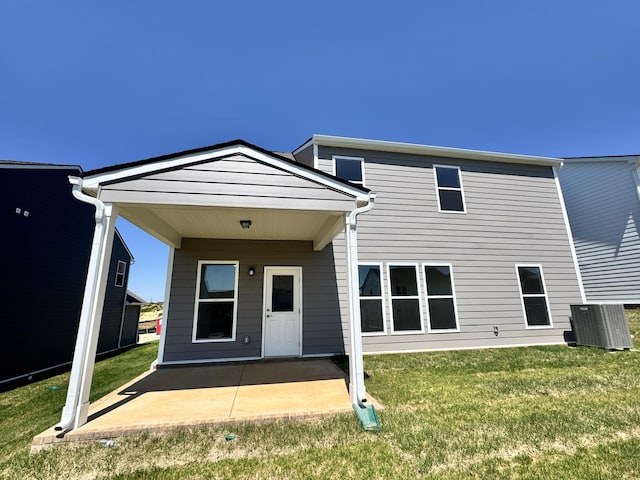 back of property with a patio area, cooling unit, and a lawn