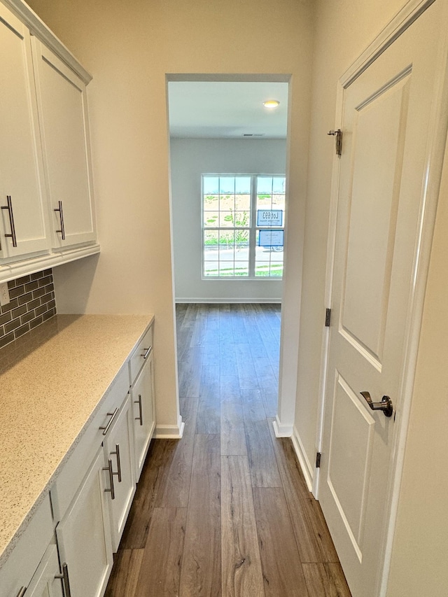 hallway with baseboards and dark wood-style floors