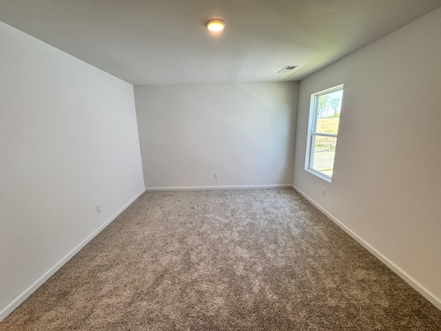 carpeted empty room with visible vents and baseboards