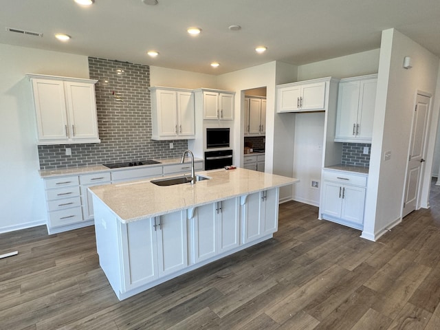 kitchen featuring a sink, white cabinets, and black appliances