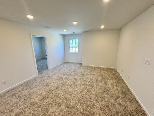 spare room with light carpet, baseboards, visible vents, and recessed lighting