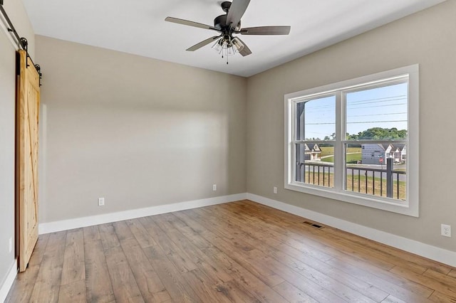 2717 Autumn Woods Trl, Cookeville, TN 38501 - unfurnished room featuring a barn door, hardwood / wood-style floors, baseboards, and a ceiling fan